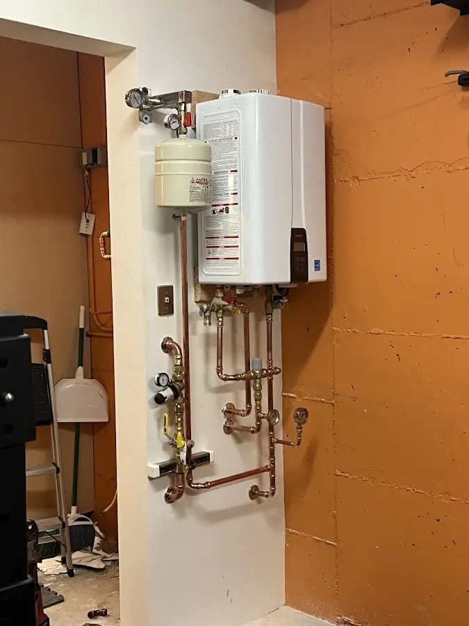 Plumbing technician inspecting water heater connections in Murray